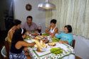Brazilian family eating dinner at the table in their home, Brazil.