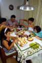 Brazilian family eating dinner at the table in their home, Brazil.