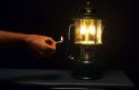 A match being used to light a gasoline lantern.