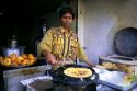 Street vendor at an open air restaurant making paratha in Delhi, India.