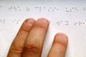 Fingers reading braille.