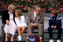 Grandparents visit with their grandchildren on a park bench in London, England.