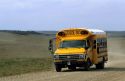 A school bus traveling on a rural dirt road in Oklahoma.