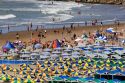 Colorful umbrellas and cabanas accent beach scene at Mar del Plata, Argentina.