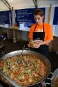Worker serves a seafood dish of paella at Mar del Plata, Argentina.