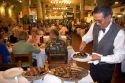 Waiter serving steaks at Estancia a famous restaurant in Buenos Aires, Argentina.