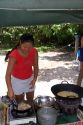 Tahitian woman cooking at a roulotte, food van on the island of Moorea.