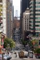 California Street scene with traffic and cable car in San Francisco, California. Bay Bridge tower in background.