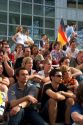 A crowd of soccer fans gather outdoors at the Munich airport watch a 2006 World Cup match on big screen televisions, Germany.