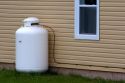 Propane fuel tank outside a house with supply line.
