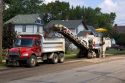 A road construction crew uses machinery to recycle asphalt in Oceola, Iowa.