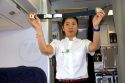 Flight attendent showing seat belt safety instructions before take off.