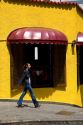 Woman walking in front of a brightly colored building in Sao Paulo, Brazil.