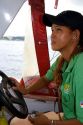 Brazilian woman listens to an MP3 player while driving an Amazon river boat at Manaus, Brazil.