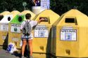 A woman depositing newspaper in recycling bins in Munich, Germany.