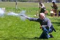 Man dressed as a Confederate soldier shooting a gun during a civil war reenactment near Boise, Idaho.
