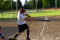 Man playing a game of softball in a park in Boise, Idaho.