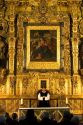 A priest performing mass in front of a gold alter inside the Catedral Metropolitana located on the central square, the zocalo, Mexico.