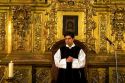 A priest performing mass in front of a gold alter inside the Catedral Metropolitana located on the central square, the zocalo, Mexico.