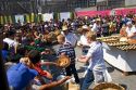 Baked bread in the shape of a skull covered in sugar being given away to a crowd of people celebrating the Day of Dead in the Zocalo in Mexico City, Mexico.
