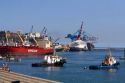Queen Elizabeth II cruise ship, a container ship, and tug boats in the Port at Valparasio, Chile.