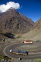 Trucks drive on switchback roads in the Andes Mountain Range in Chile.