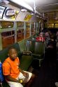 Black boy sitting in Rosa Parks city bus seat on display at The Henry Ford Museum in Dearborn, Michigan.