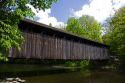 Whites Bridge, a brown truss covered bridge spanning the Flat River in Keene Township, Michigan.