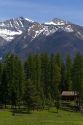Log cabin sits below the Rocky Mountains near Condon, Montana.