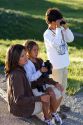 Hispanic family viewing wildlife with binoculars in Yellowstone National Park, Wyoming. MR