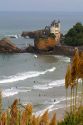 Surfing Cote de Basque below a castle in the Bay of Biscay at the town of Biarritz, Pyrenees Atlantiques, French Basque Country, Southwest France.