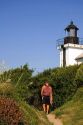 Man walking on a path to the lighthouse at Saint-Jean-de-Luz, Pyrenees Atlantiques, French Basque Country, Southwest France.