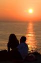 Couple watching the sunset over the Atlantic Ocean at Saint-Jean-de-Luz, Pyrenees Atlantiques, French Basque Country, Southwest France.