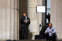 News reporters on the steps of Federal Hall located at 26 Wall Street in New York City, New York, USA.