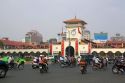 Vietnamese people ride motorbikes in front of the Ben Thanh Market in Ho Chi Minh City, Vietnam.