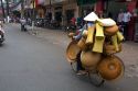 Vietnamese man riding a bicycle with many baskets in Ho Chi Minh City, Vietnam.