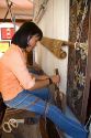 Vietnamese woman manufacturing woven rugs at a craft center in Hoi An, Vietnam.