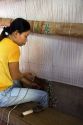 Vietnamese woman manufacturing woven rugs at a craft center in Hoi An, Vietnam.