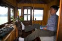 Vietnamese boat captin steering with his feet in Ha Long Bay, Vietnam.