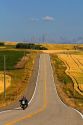 Motorcycling along Idaho Highway 32 with the Teton Range in the distance near Ashton, Idaho, USA.
