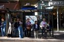 People wait at the Les Ecoles bus stop along Boulevard Saint-Michel in the Latin Quarter of Paris, France.
