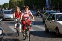 People ride bicycles along the Avenue des Champs-Elysees in Paris, France.