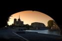 View of the Notre Dame cathedral at sunset through the arch of the Tournelle Bridge on the River Seine in Paris, France.