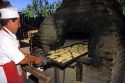 Chilean man cooking empanadas in a brick oven in Sanitiago, Chile.