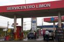Attendants pump fuel at a gas station in Limon, Costa Rica.
