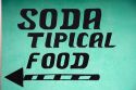 Spanish language sign directing to a small restaurant called a soda near the town of Nuevo Arenal, Costa Rica.