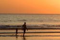 People walk on the beach at sunset in Jaco, Costa Rica.