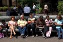 People sit on park benches in the city of San Jose, Costa Rica.