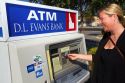 Woman making a cash withdrawal from and ATM in Boise, Idaho, USA. MR