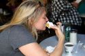 Woman eating a beignet at Cafe Du Monde in the French Quarter of New Orleans, Louisiana, USA.